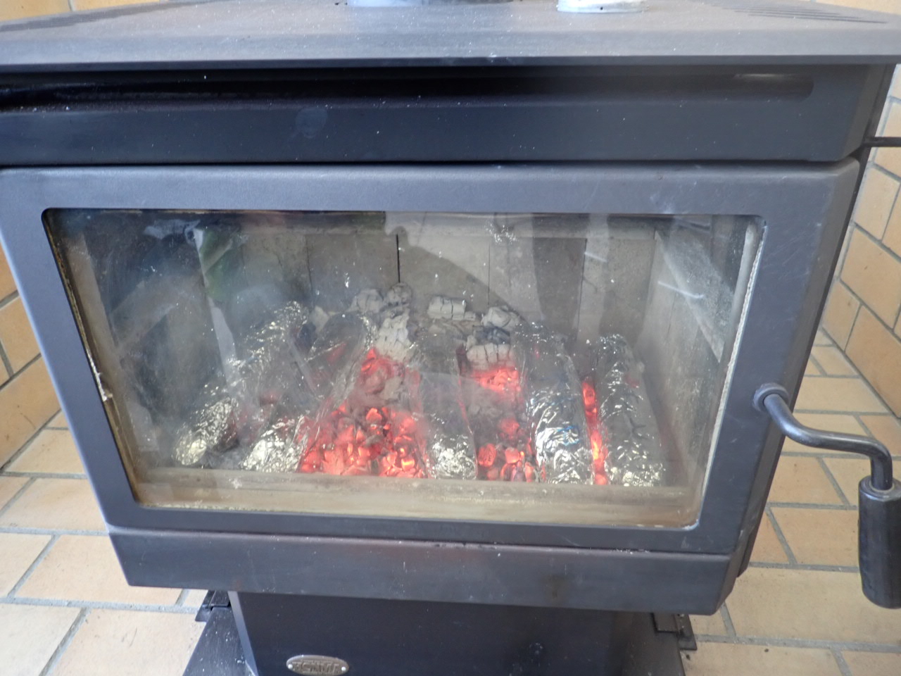 薪ストーブでさつまいもを焼く